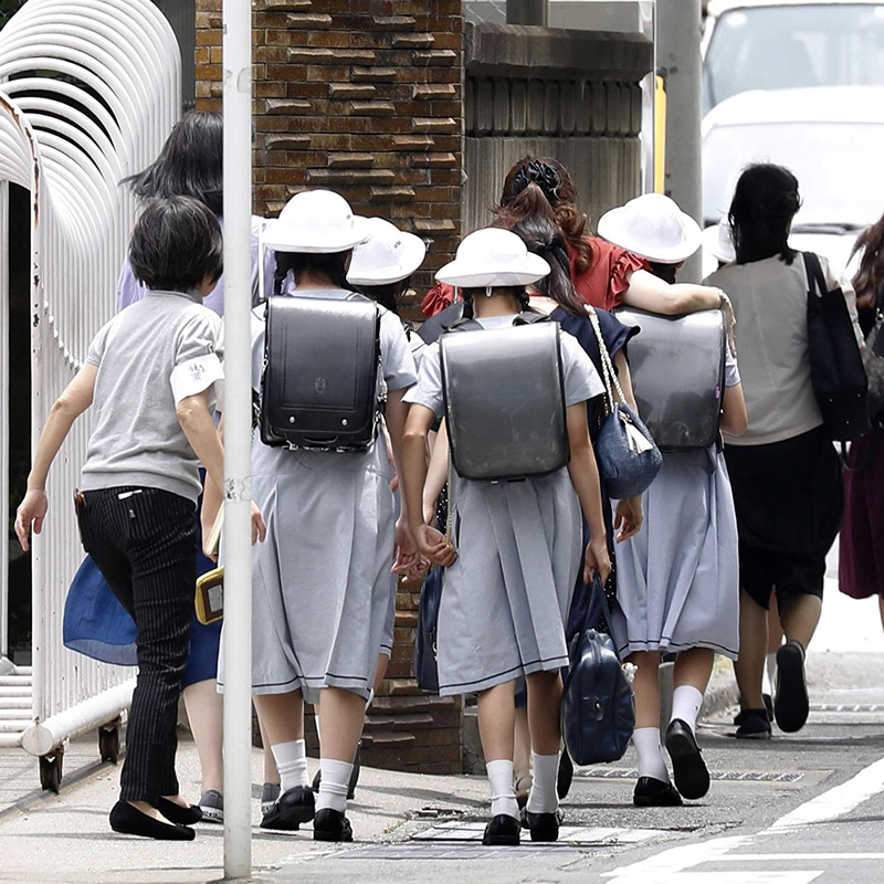 أولياء الأمور يرافقون أطفالهم بعد الحادثة المروعة بالقرب من طوكيو - وكالة كيودو 