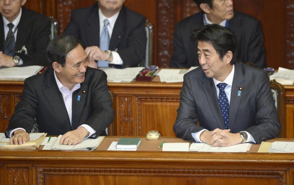 يوشيهيديه سوغا (يمين) وشينزو آبيه (يسار) خلال جلسة برلمانية عام 2013 | عبر مكتب رئاسة الوزراء وكيودو