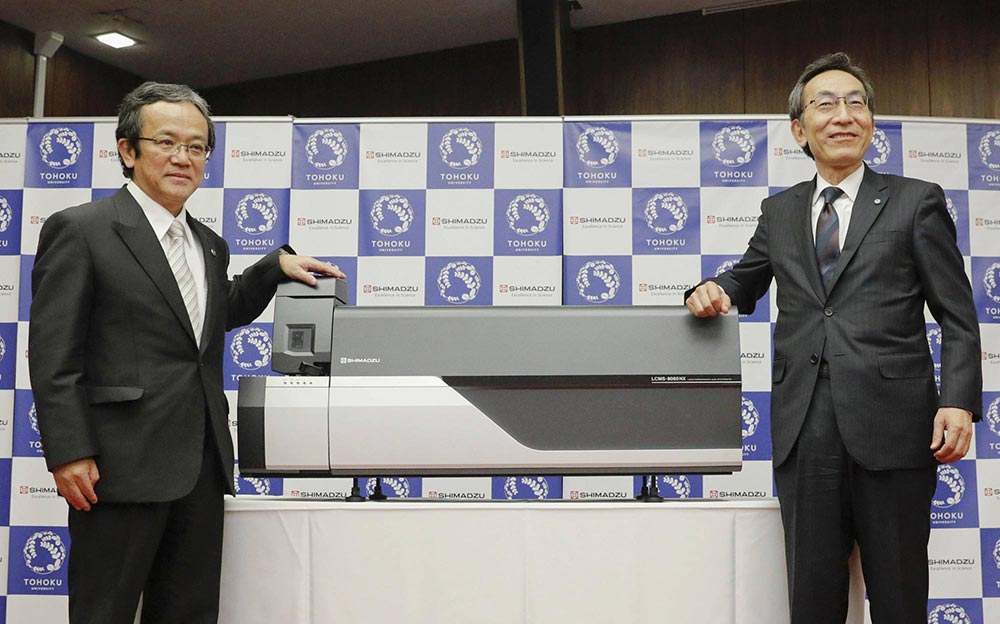 رئيس شركة شيمادزو "تيروهيسا أويدا" (يسار) يقف برفقة رئيس جامعة توهوكو "هيديو أونو" (يمين) لاستعراض النظام الجديد | عبر كيودو