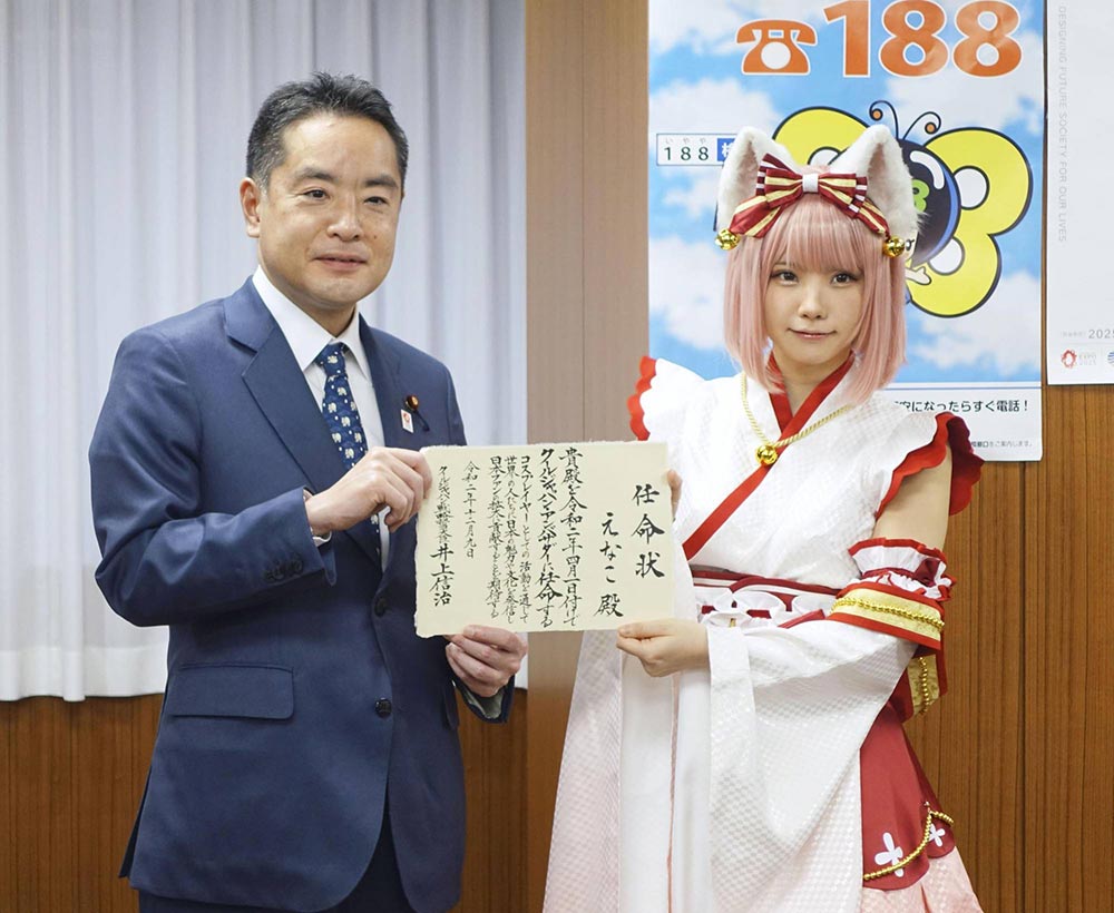 الوزير شينجي إينوئي المسؤول عن مبادرة "Cool Japan" الحكومية يُسلم رسالة لعارضة الكوسبلاي اليابانية الشهيرة "إيناكو" والتي أصبحت بموجبها سفيرة لحملة "Cool Japan" | ديسمبر 2020 | عبر كيودو